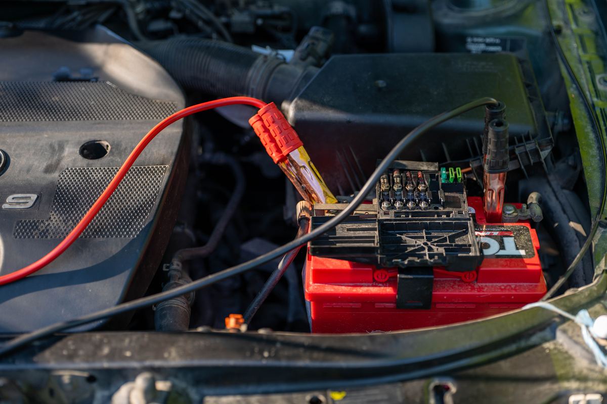 Car jump start in Tallinn — booster clamps connected to the car battery